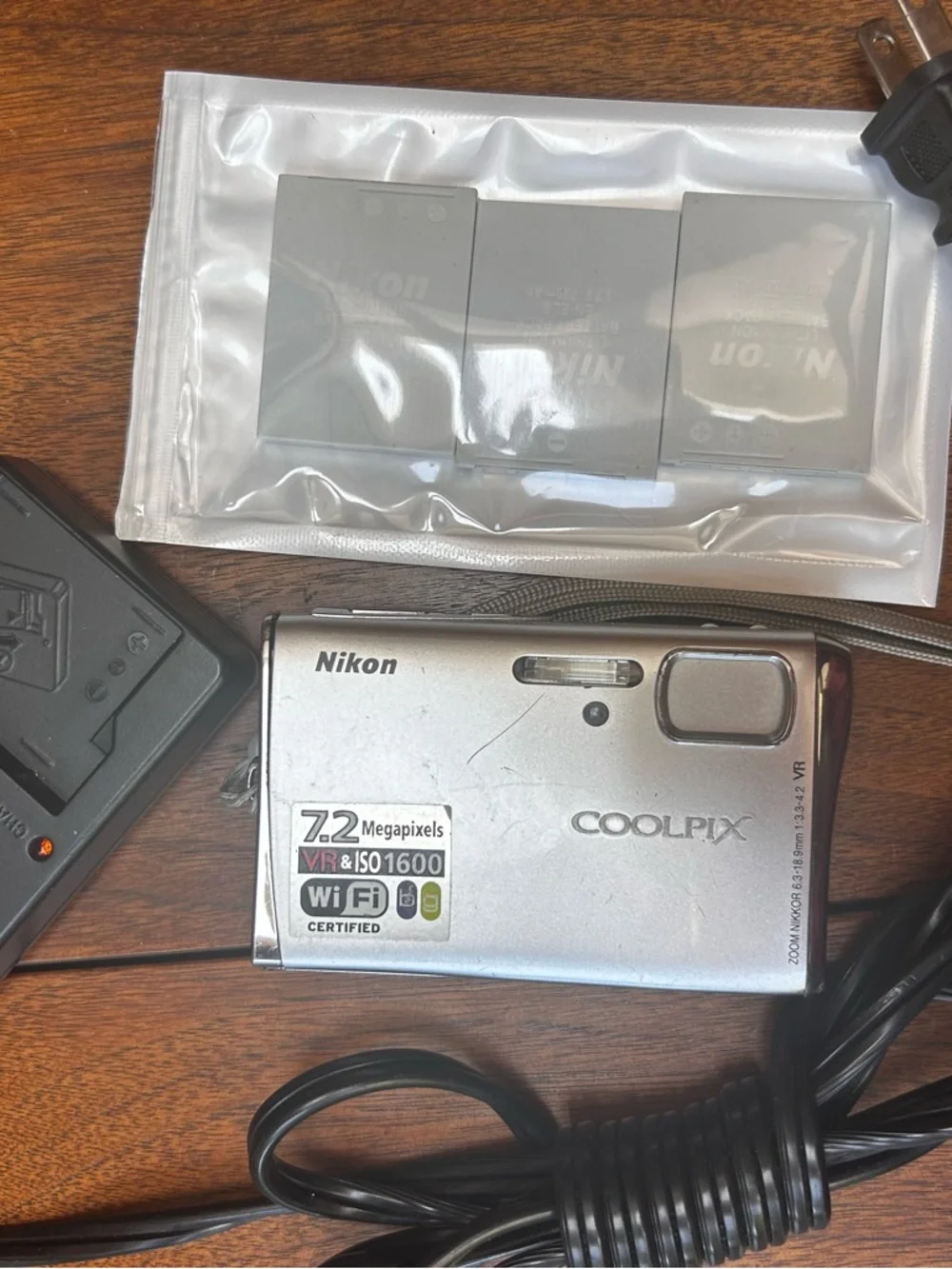 Three NEW lithium ion batteries; used charger for Nikon Coolpix camera.